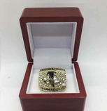 Gold 1998 Atlanta Falcons NFC Championship Ring with diamonds in a wooden box on a white background