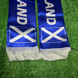Blue Scottish scarf with white fringe and Scottish flag design on a grass background