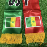 Two scarves with Senegalese flag design on a grass background