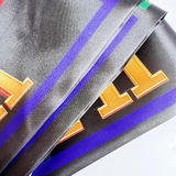 Close-up of a fabric of  South Africa Scarf with orange letters and purple stripes on a gray background