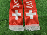 Red Switzerland scarf with white crosses on a green grass background
