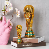 Gold soccer trophy on books with a pink vase and flowers in the background
