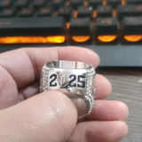Replica of Ohio State 2025 Championship Ring with '2025' on a hand in front of a keyboard